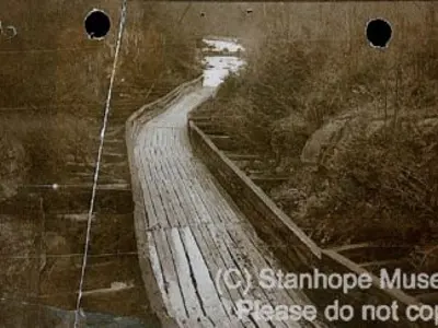 Image shows a black and white picture of the Hawk Lake Log Chute without water in it. 