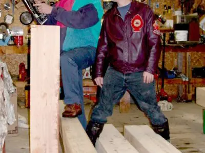 Image shows men working with large timbers. 