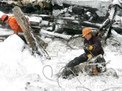 Image shows men in hardhats working in the snow. 