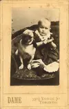 Image shows a picture of a baby sitting beside a dog. 