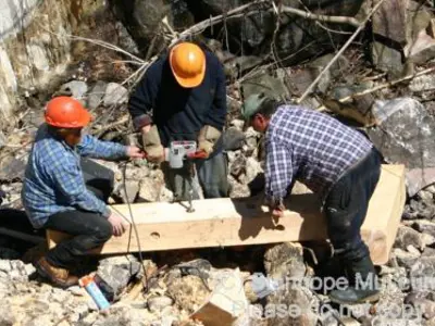 Image shows men in hardhats looking at plans. 