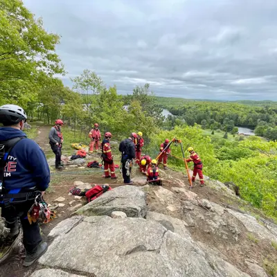 Image shows a group of volunteer firefighters on a cliff. 