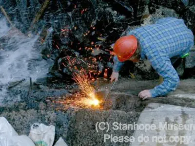 Image shows a man welding. 