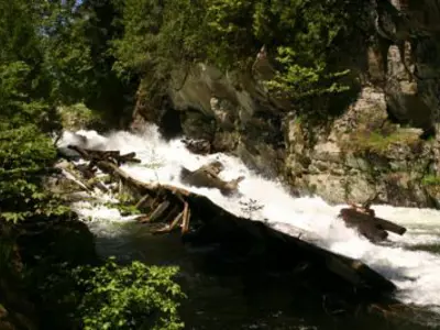 Image shows water pouring through a broken log chute. 