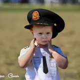 Image shows a child wearing a fire captain's hat. 