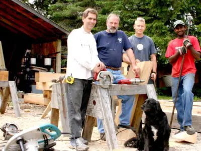 Image shows a group of people posing with a dog. 