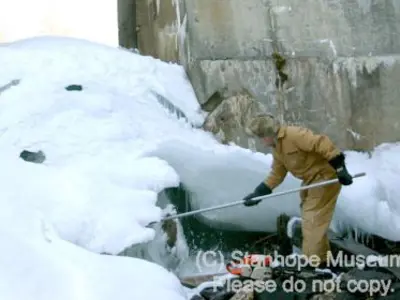 Image shows a man working beneath the dam. 