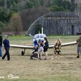 Image shows fly-in guests looking at a small plane. 