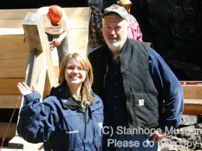 Image shows man standing with a television reporter. 