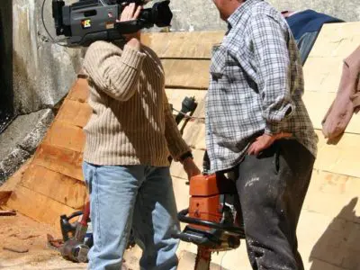 Image shows a man being interviewed by a television reporter. 