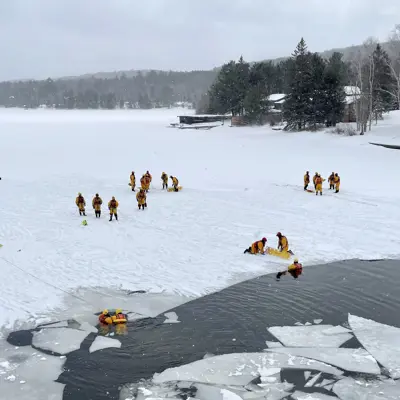 Image shows firefighters conducting ice rescue training. 