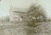 Image shows a faded picture of a log cabin. 