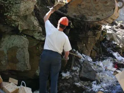 Image shows men in hardhats working. 