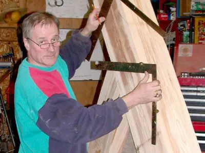 Image shows men working with large timbers. 