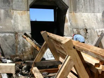 Image shows frame of the new log chute in place with the dam in the background. 