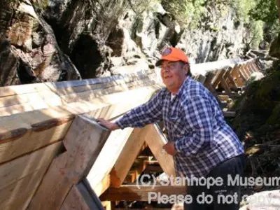 Image shows a man in a hardhat putting finishing touches on the new log chute. 